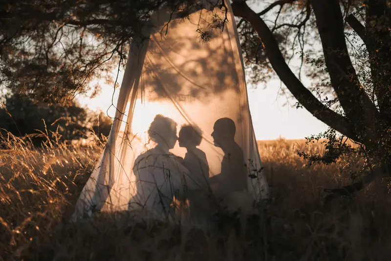 Ombres d'une famille sur la toile d'une tente, au coucher du soleil