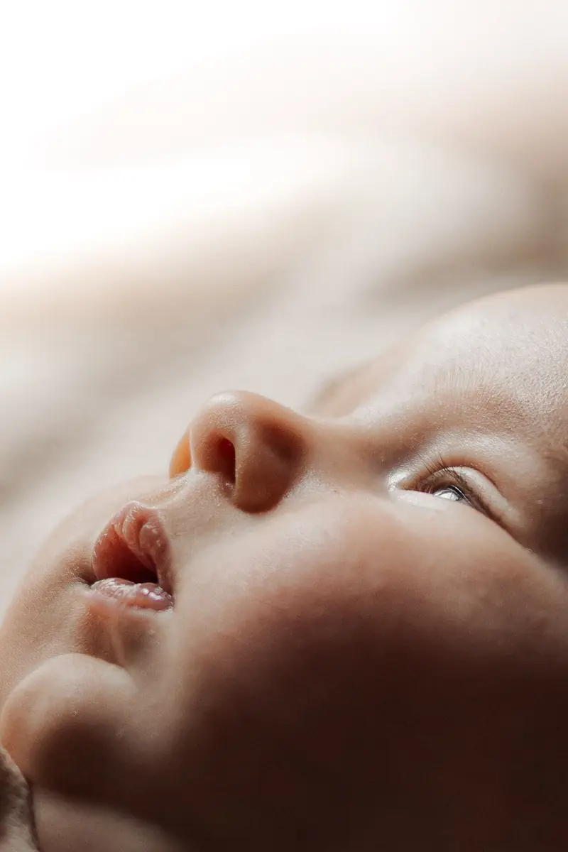 Gros plan sur le profil d'un nouveau-né, le nez et la bouche entrouverte dans une lumière douce