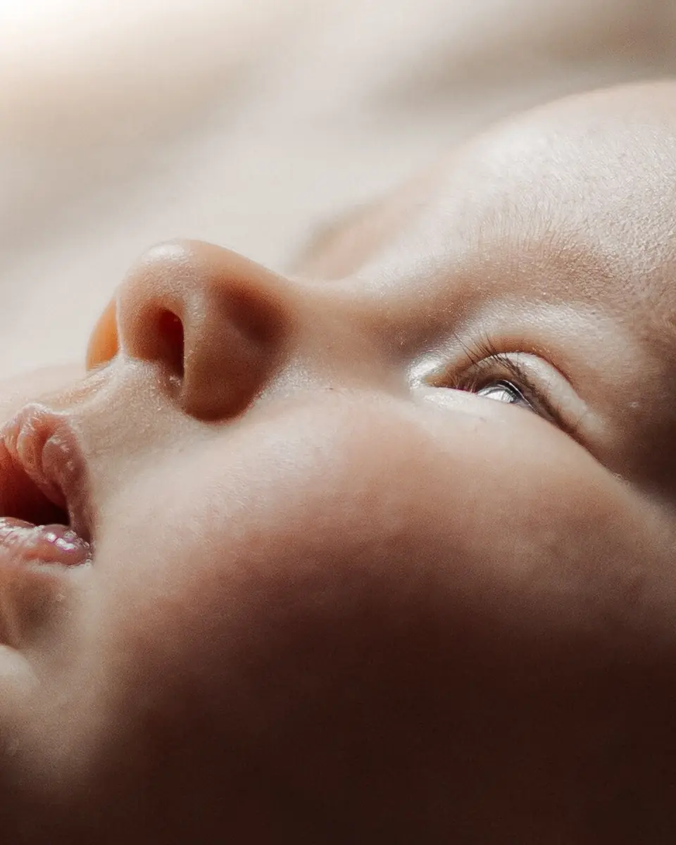 Le visage d'un bébé endormi vu de profil, la bouche entrouverte